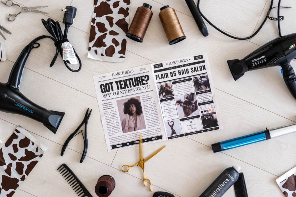 A vintage-style printed newspaper with beauty tools around it on a wooden surface.