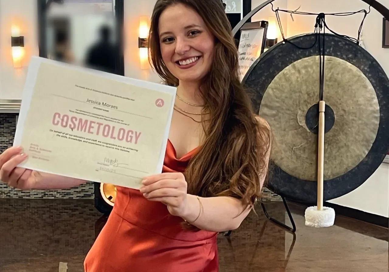 rs=w_1280 (7) A woman holding up her cosmetology certificate.